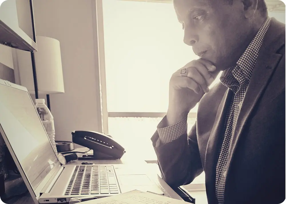 Person in suit working thoughtfully at laptop