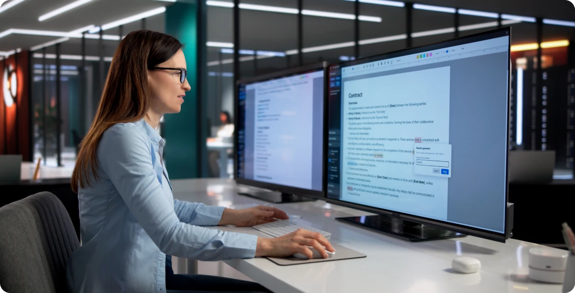 Person working at dual monitors in modern office